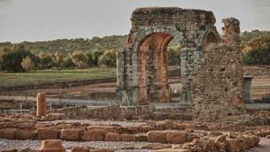 Vista del yacimiento arqueológico de Cáparra con el arco cuadriforme, y restos de las domus