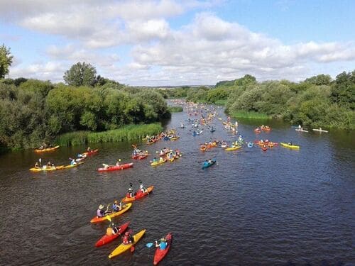 Cientos de personas realizando el descenso en canoa por el río Alagón